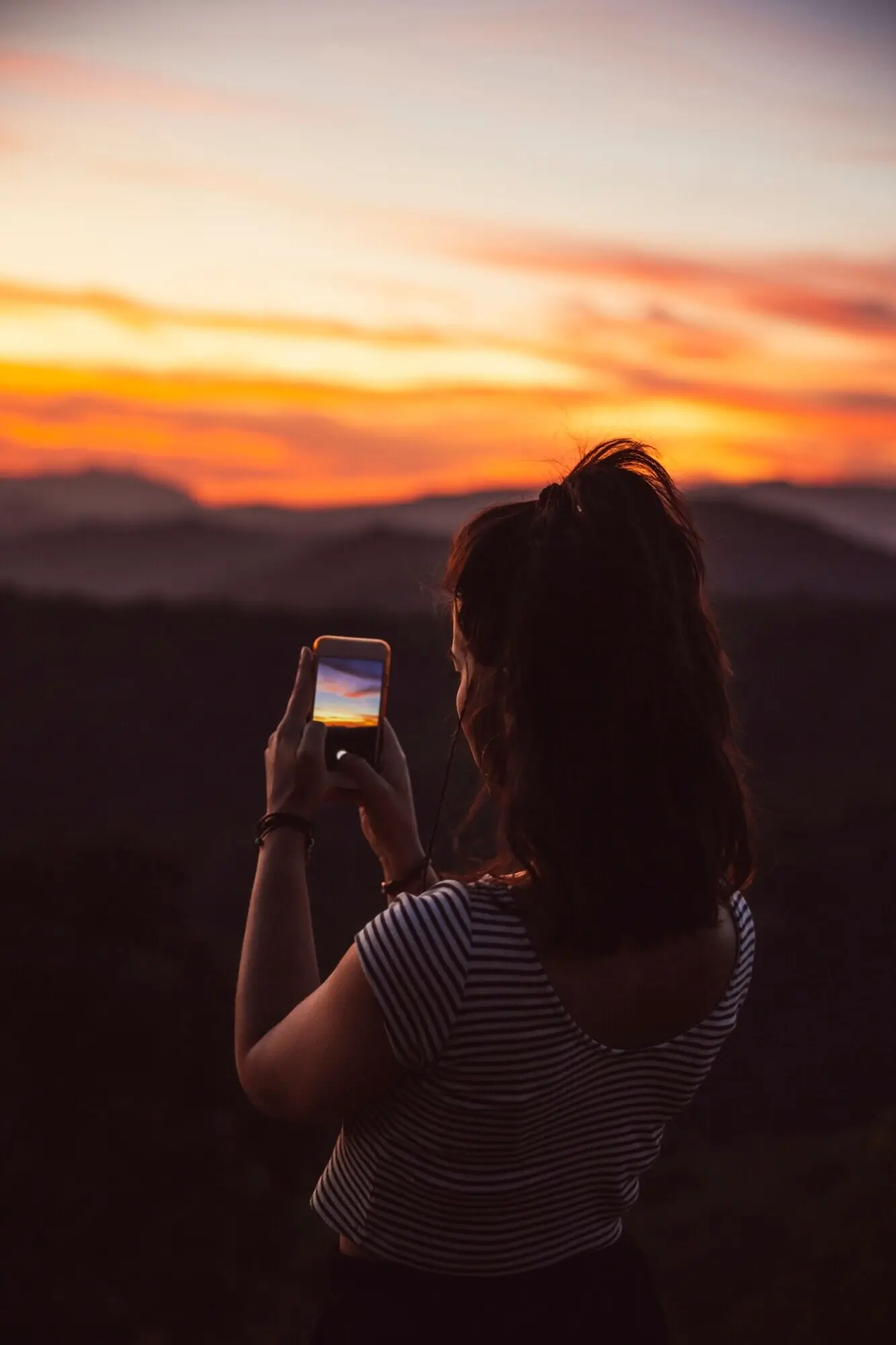 A traveler photographing the sunset.