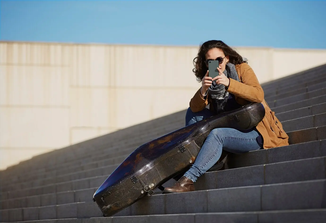 A beautiful young woman using his cell phone to take a photo.