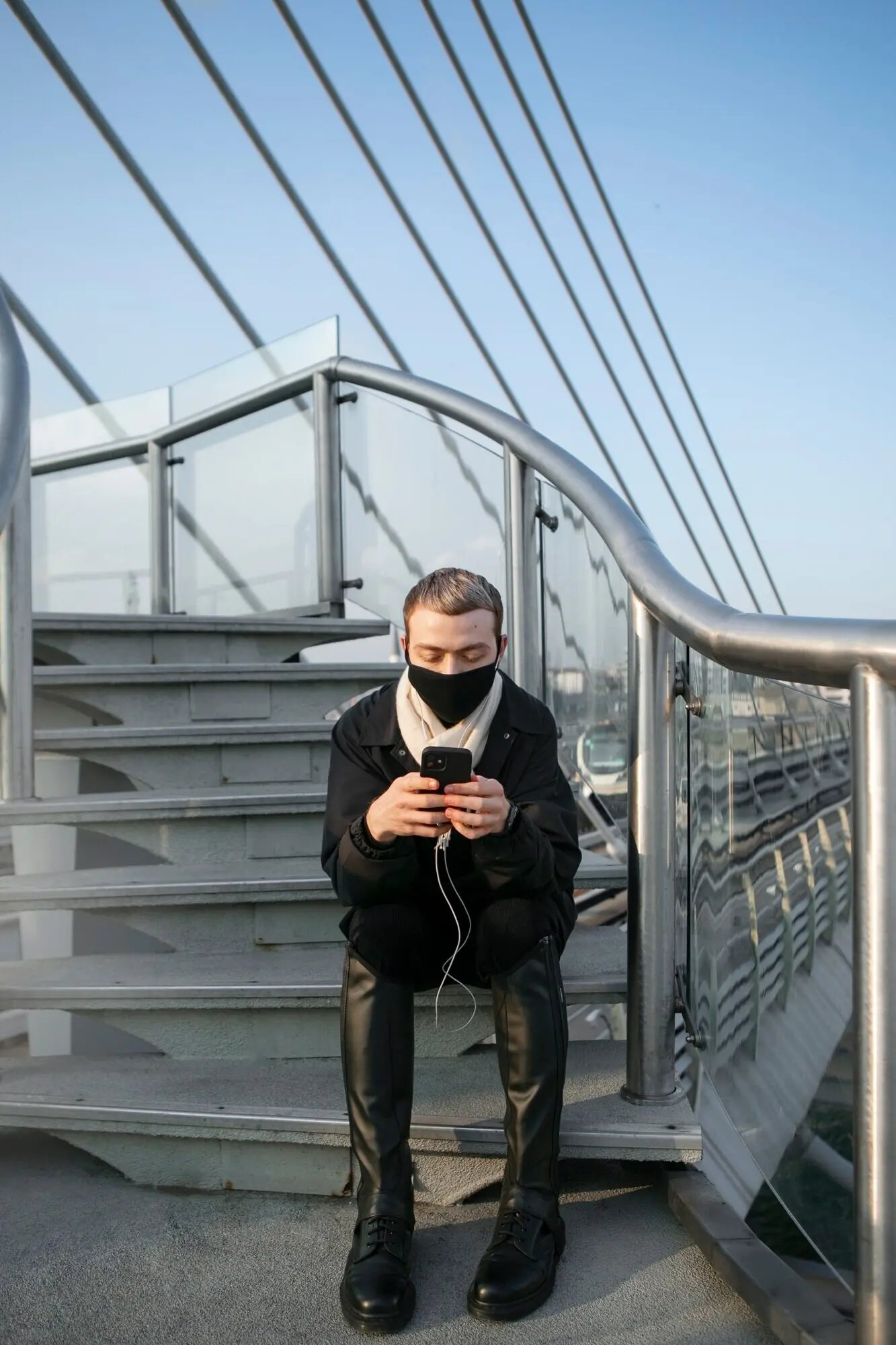 A male tourist checks his smartphone while sitting on the stairs.